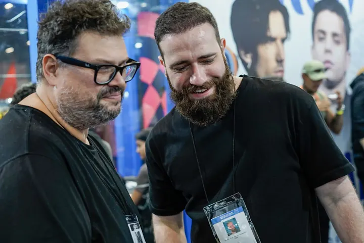 Dois homens conversando e sorrindo em um estande
