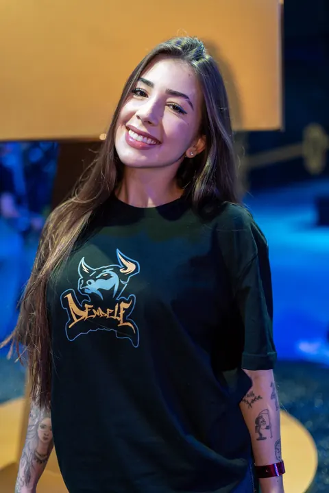Criadora sorrindo com camiseta preta na arena