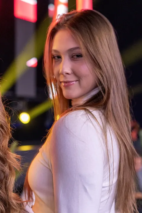 Mulher de blusa branca olhando para a câmera